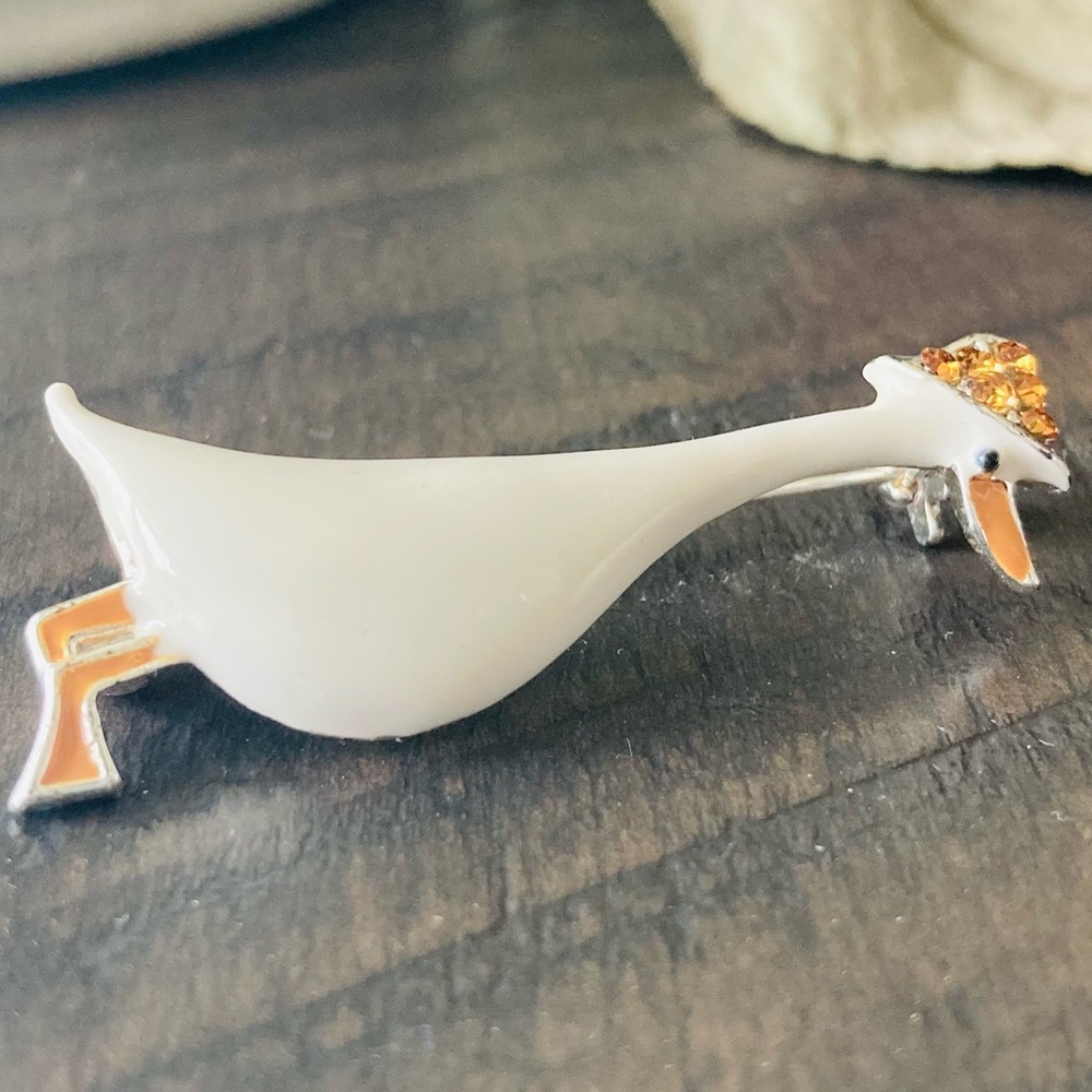 Vintage love signed white enamel duck brooch with orange colored rhinestone cap.